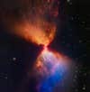 A star is forming out of a hot mass of gas, in a shape like a sand clock.