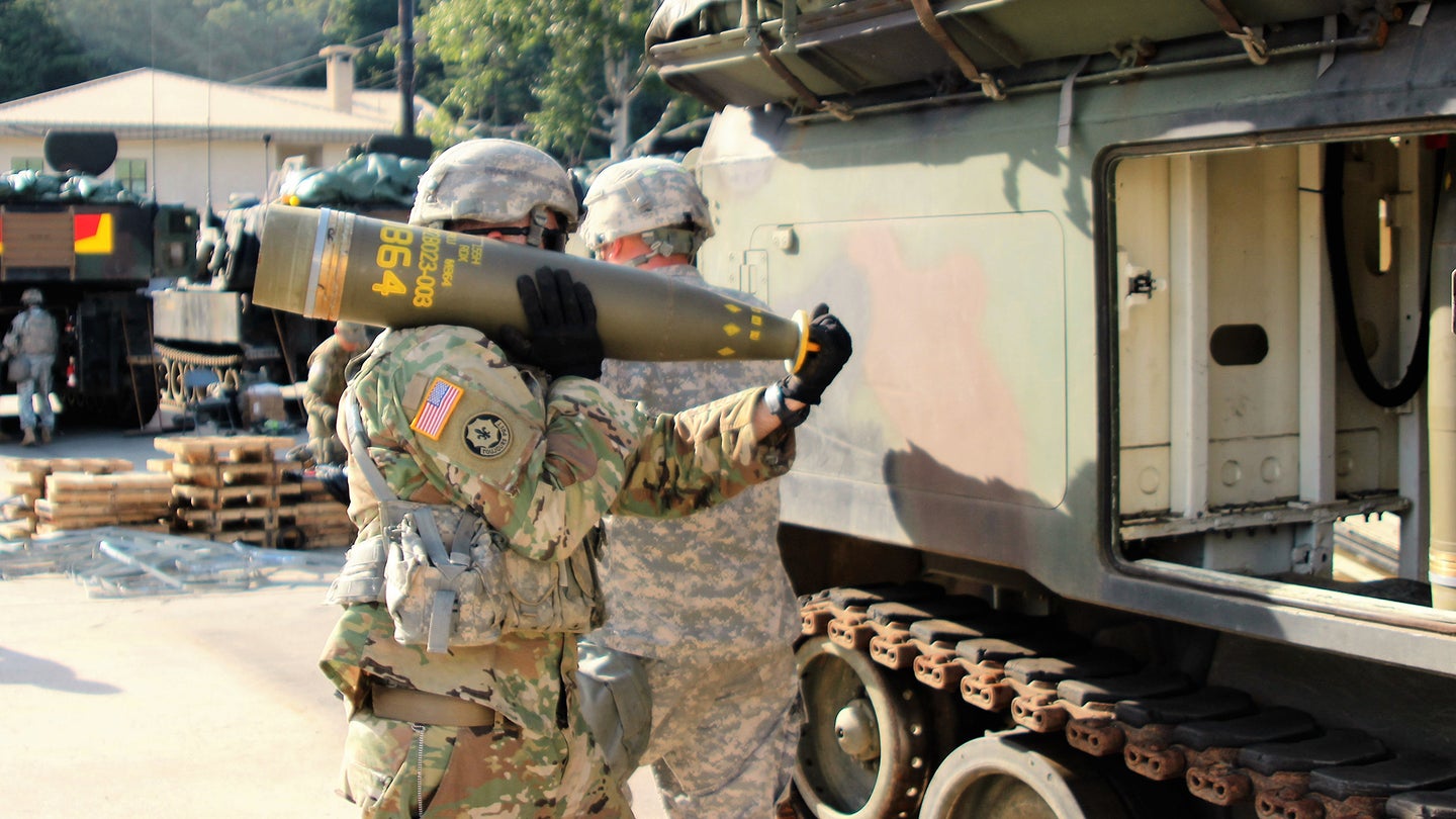 A US soldier holds a cluster bomb shell