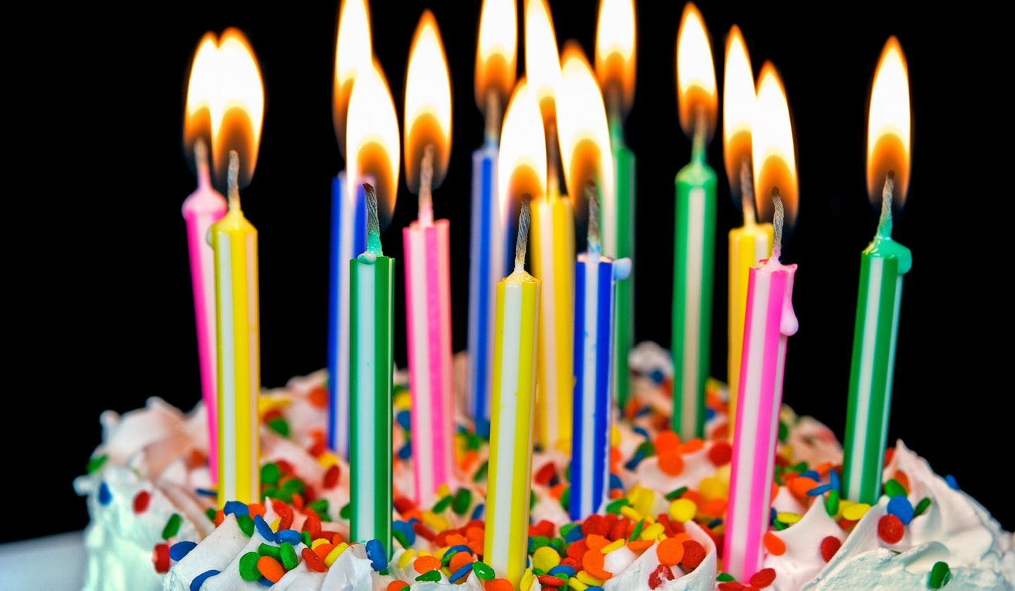 Sprinkle-filled birthday cake with lit multi-colored candles. Biological age is different from the chronological age measured by birthdays.
