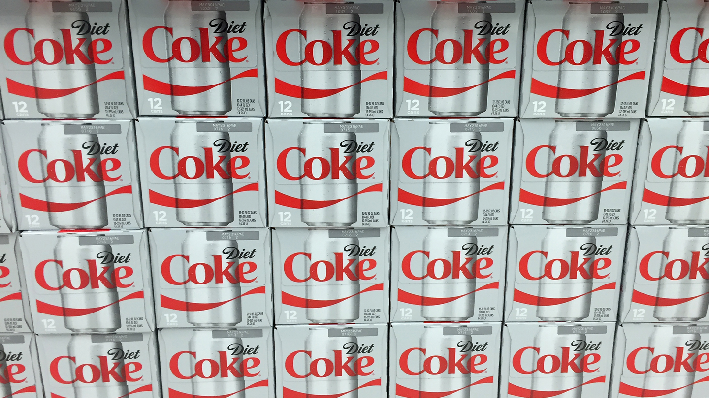 Multiple boxes of Diet Coke on a store shelf.