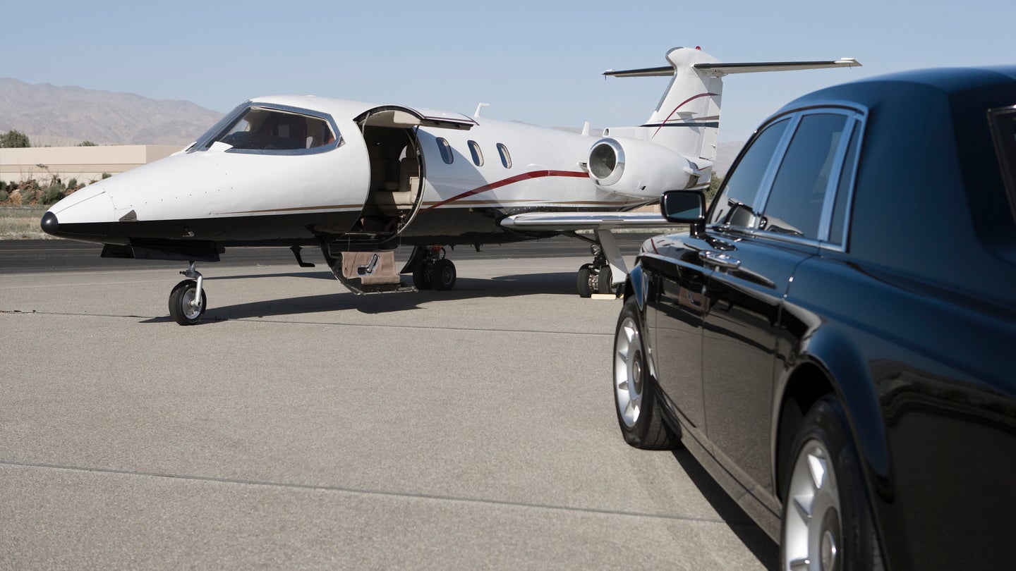 Limousine and private jet on landing strip.