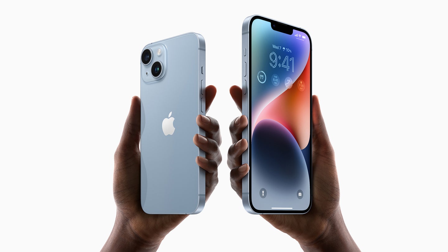 Two hands against a white background, each holding an iPhone 14. The one on the left has its silver back to the camera, while the one on the right has its screen toward the camera.