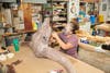 person works on fossil replica of large head with horns