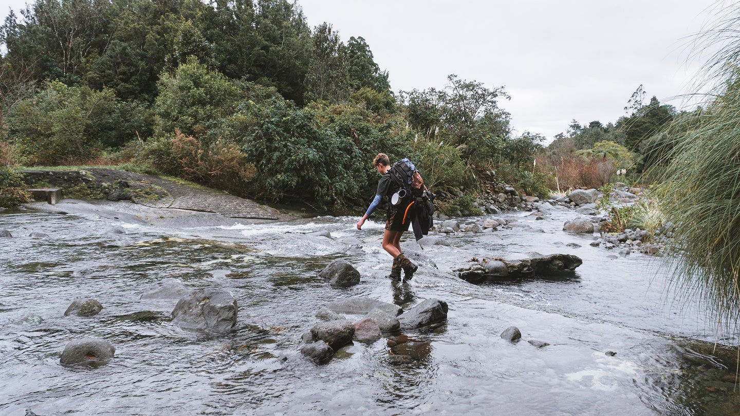 A person demonstrating how to safely cross a river or creek in the outdoors