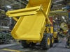 a yellow john deere dump truck in a factory