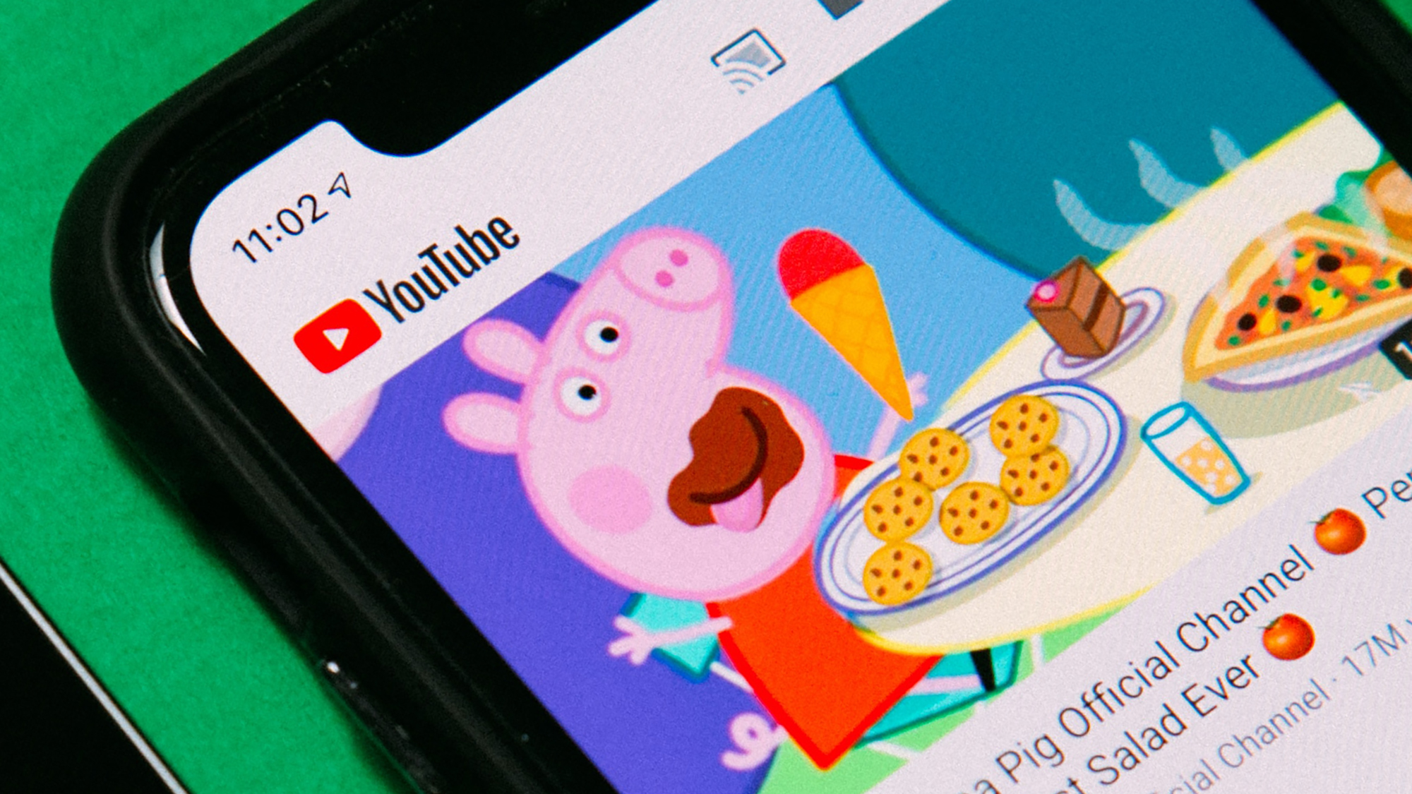 The YouTube mobile app on a phone, with a Peppa Pig video queued up to download or watch.