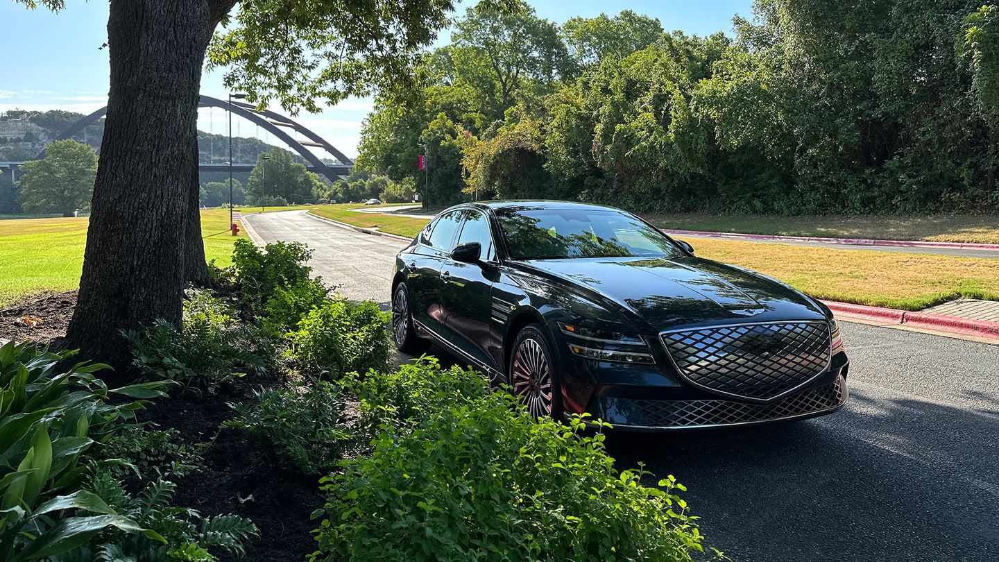 The Genesis Electrified G80 parked near a tree