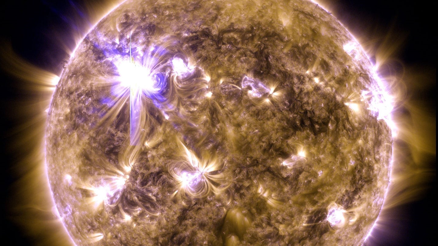 A NASA image of the sun with a bright solar flare in the upper left.