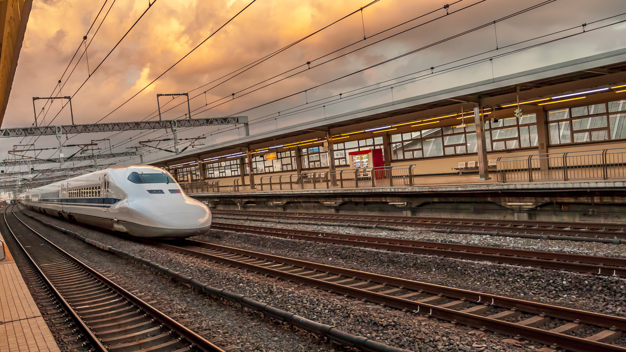 Japanese bullet train leaving station at dawn