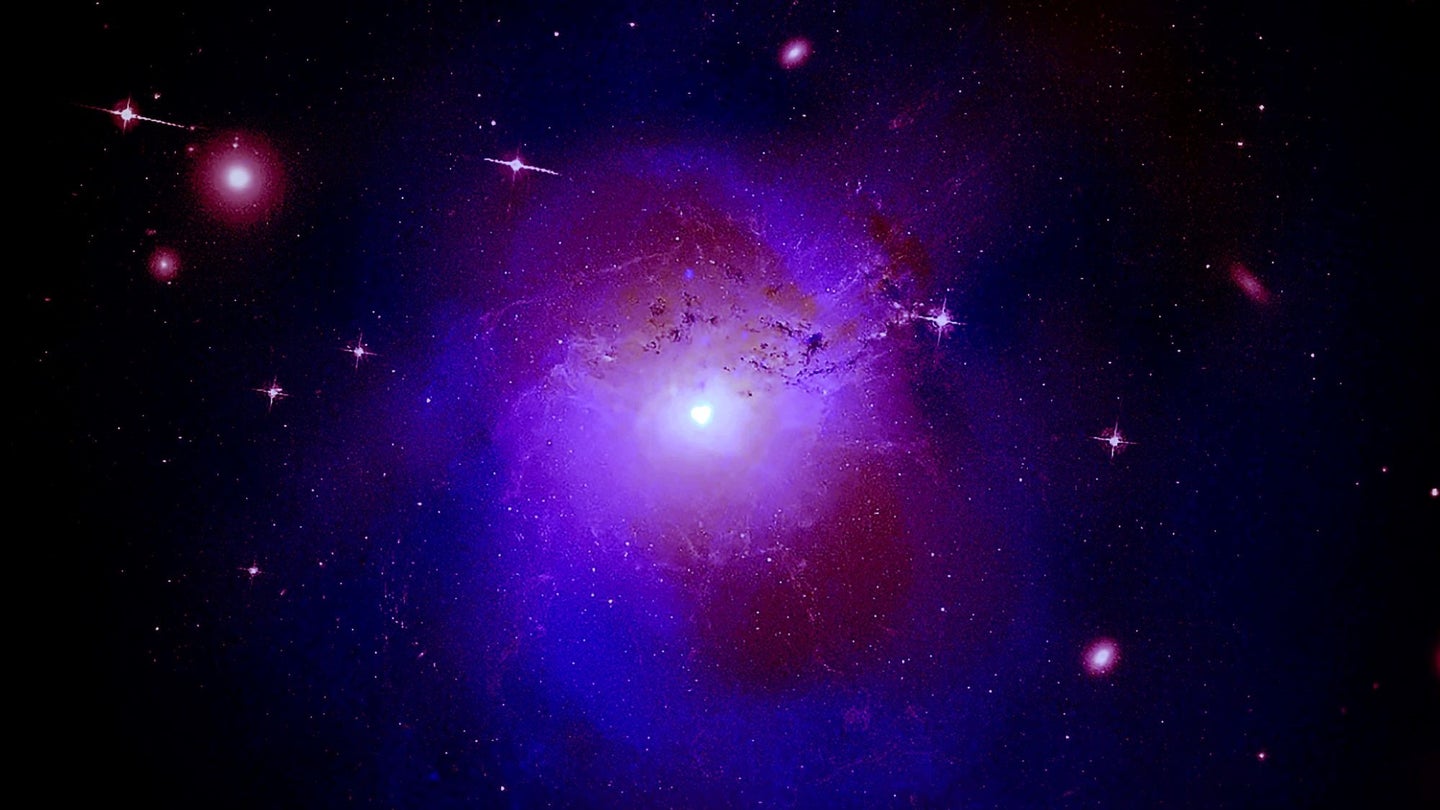 A purple galaxy cluster against a black background of space, studded with stars.