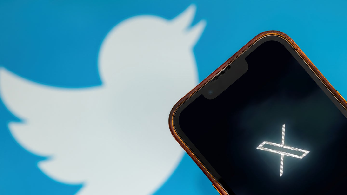 X logo on smartphone against old Twitter bird logo background