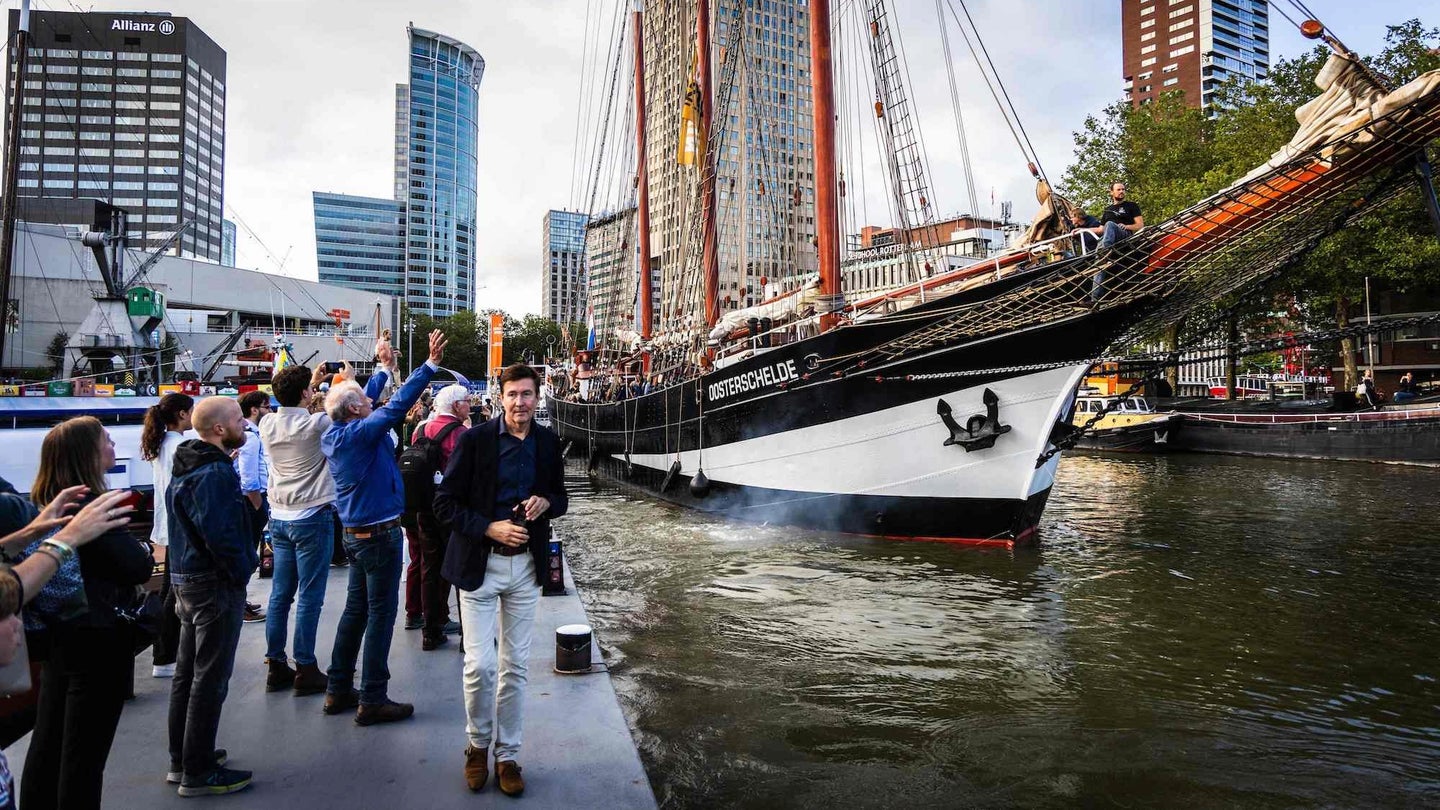 Members of the Dutch Tall Ship Oosterschelde wave goodbye from the quay in Rotterdam on August 4, 2023. The Rotterdam ship departs for a two-year world tour that scientist Charles Darwin made two centuries ago.