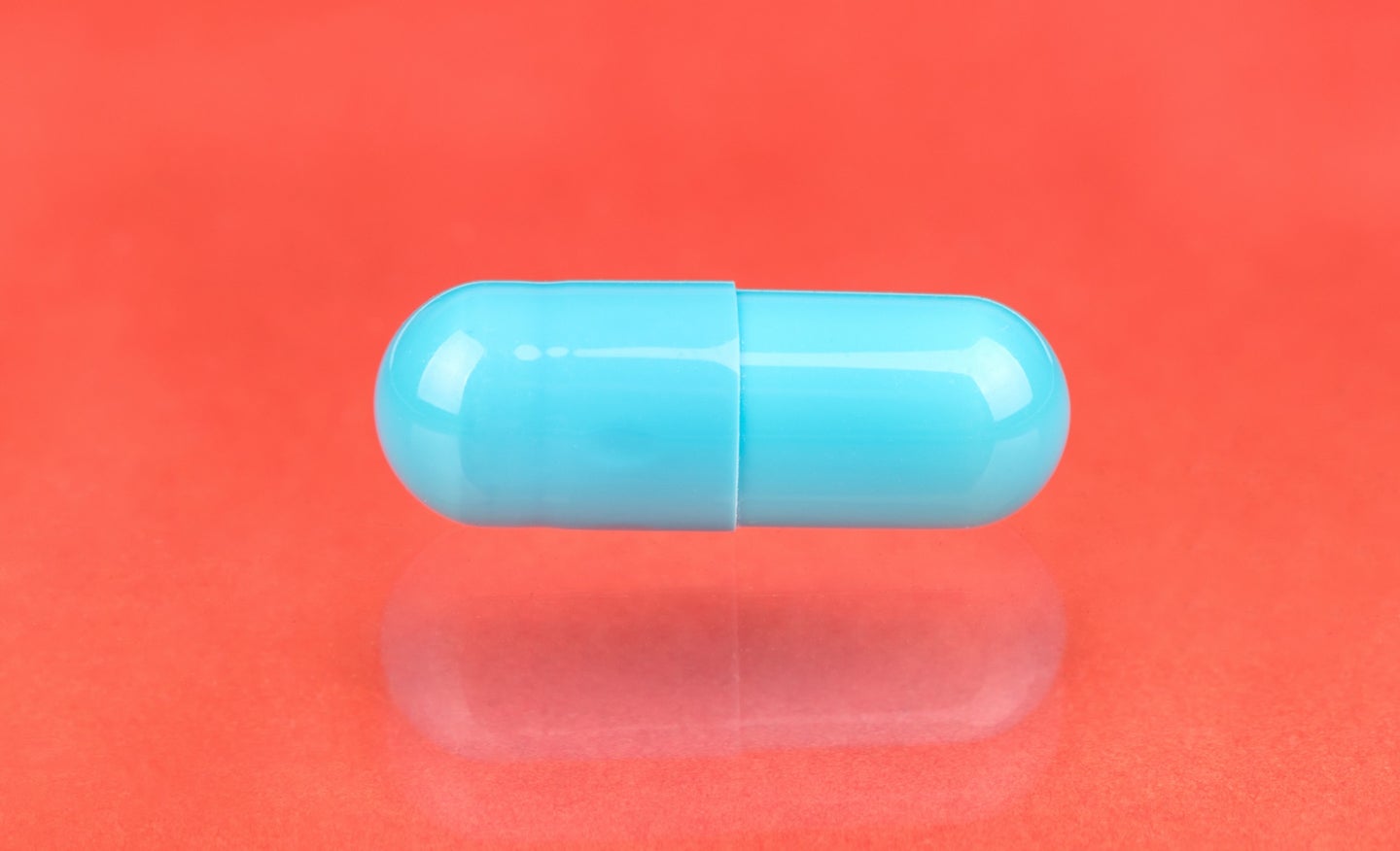 Doxycycline antibiotic pill for STI and STD prevention on a coral background