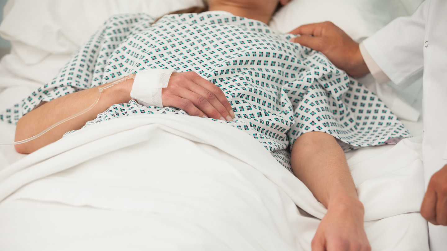A woman in a hospital, with a doctor touching her shoulder. Some of the health problems associated with long COVID include blood clots, diabetes, heart issues, blood clots, diabetes, neurologic complications, gastrointestinal disorders, fatigue, and difficulties with mental health.