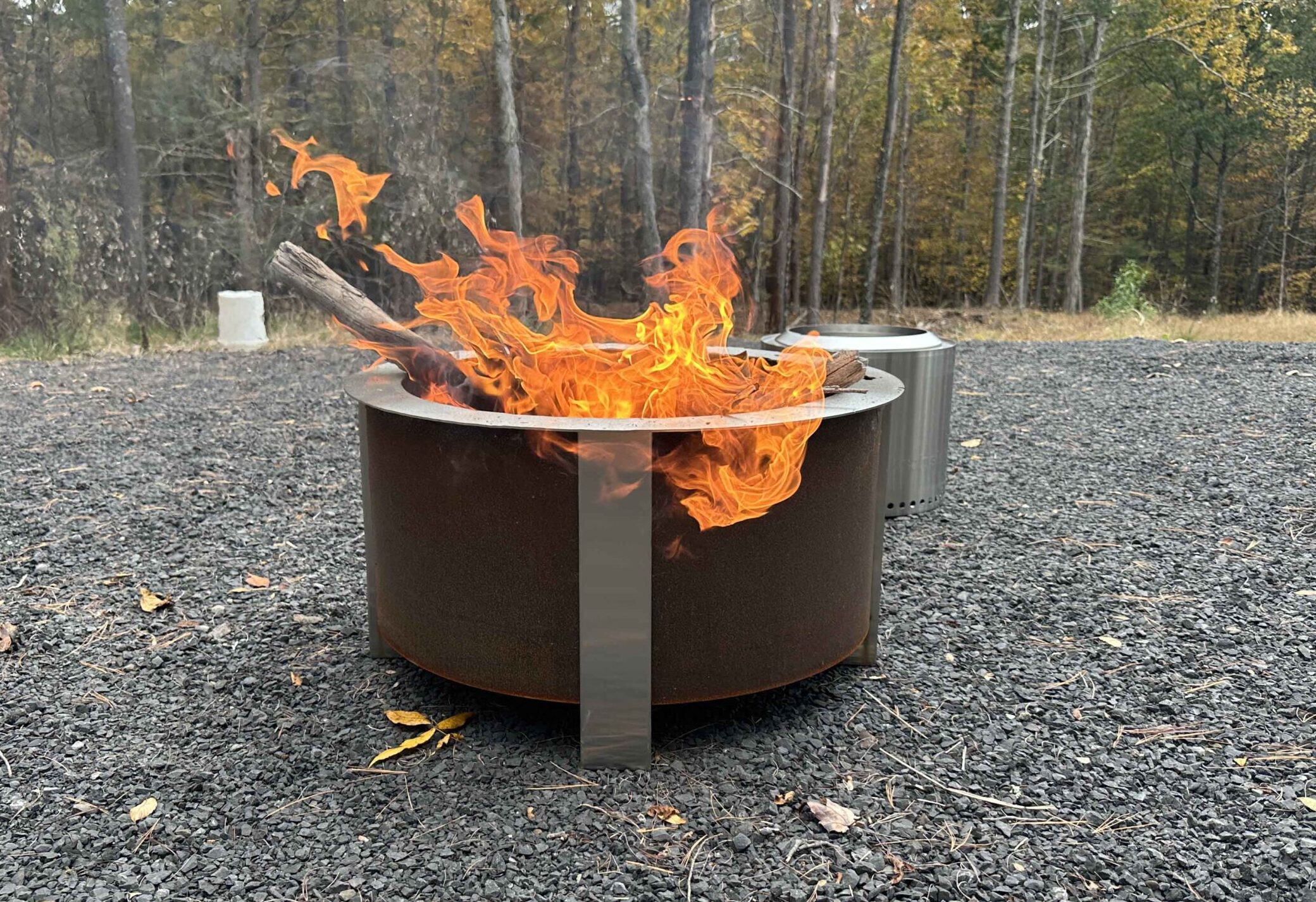 The Breeo fire pit with a fire on gravel