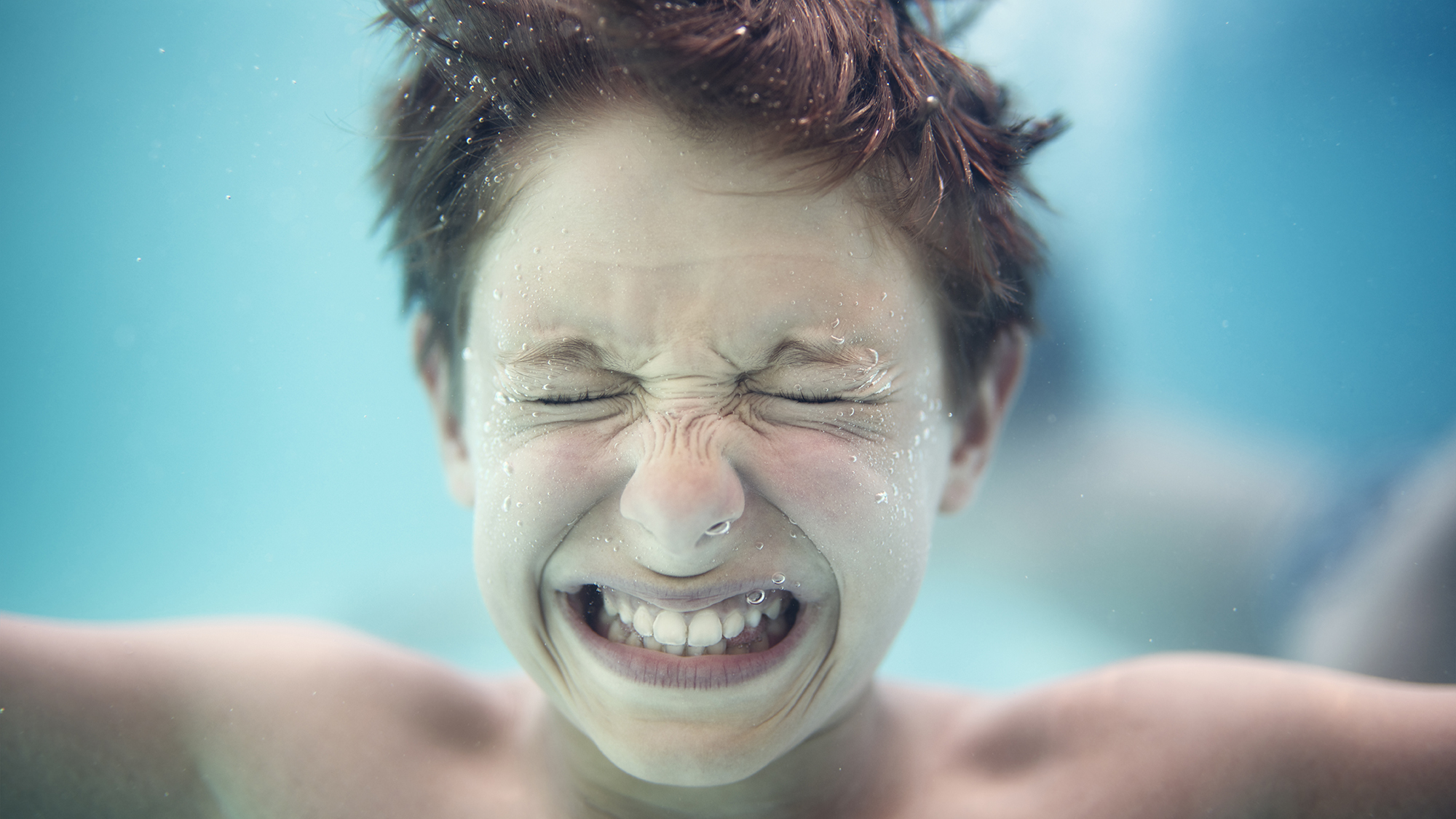 Portrait of a little boy underwater crying