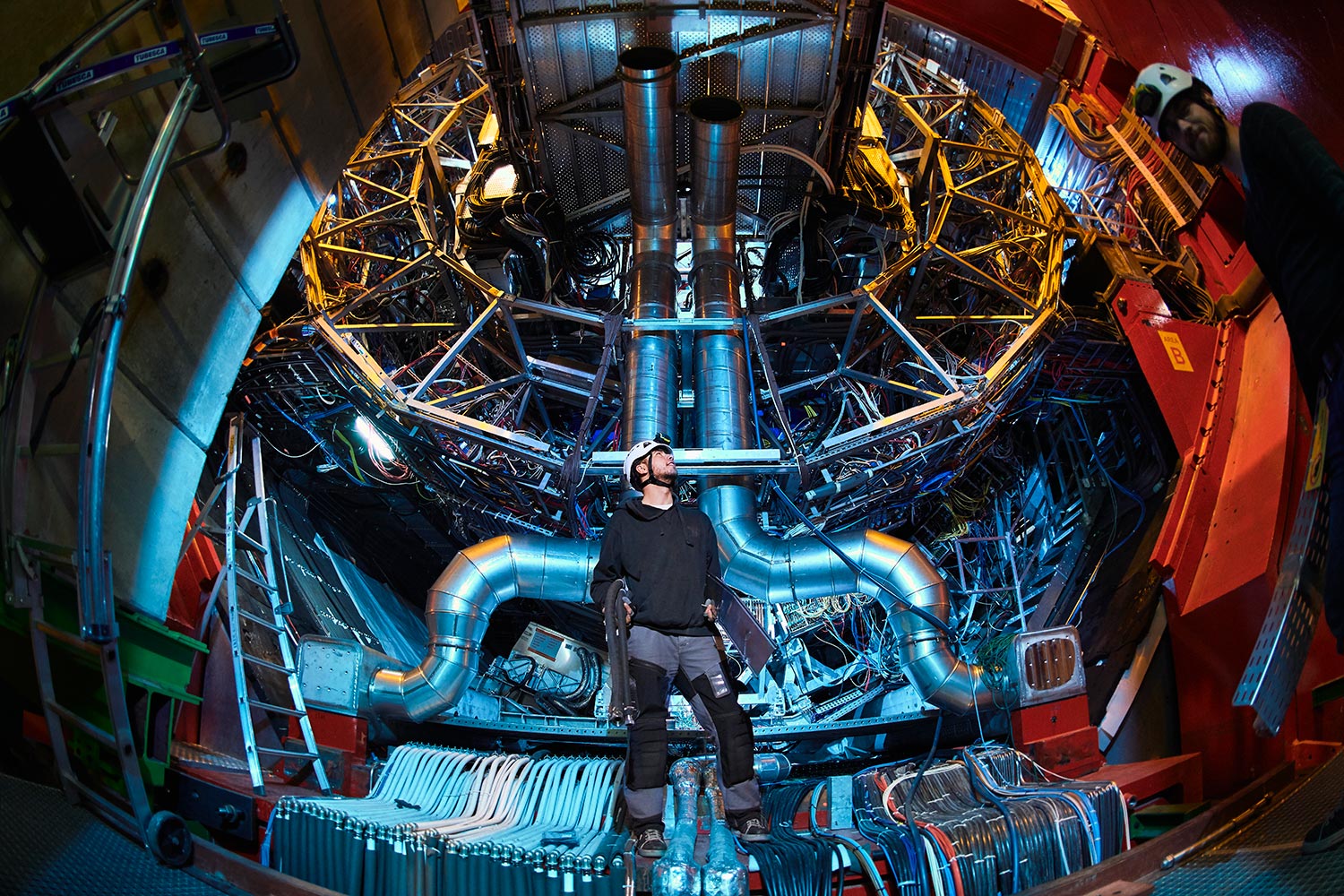 helmeted person stands inside inner workings at CERN