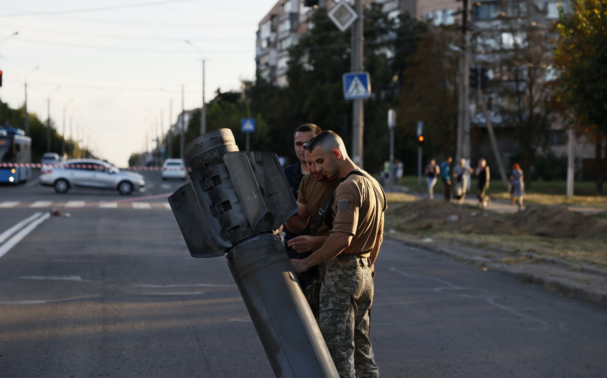 Soldiers inspect a missile that landed in a Ukraine street without detonating.