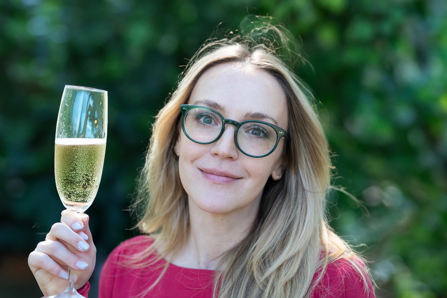 Annie Colbert holds a glass of champagne with an awkward hand.