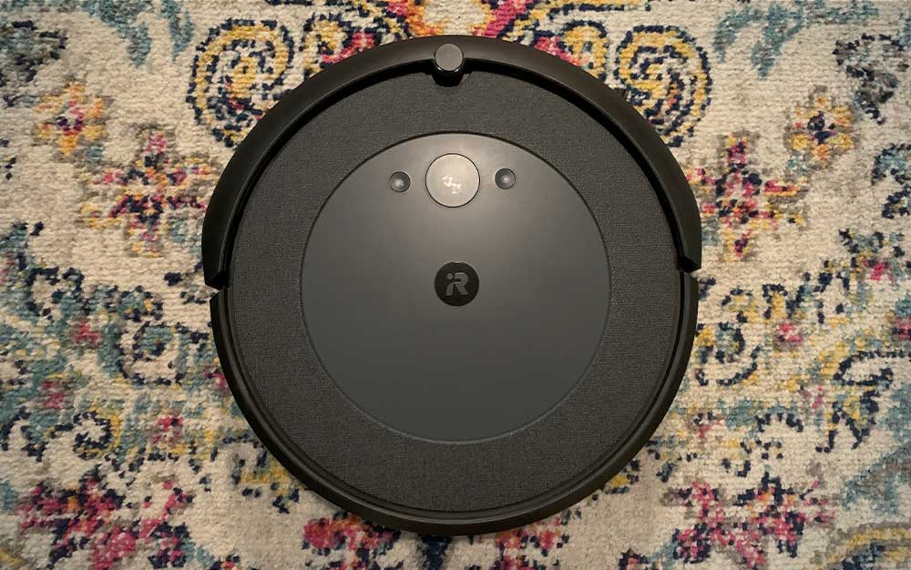 A round iRobot Roombas i4 on Jen's colorful rug