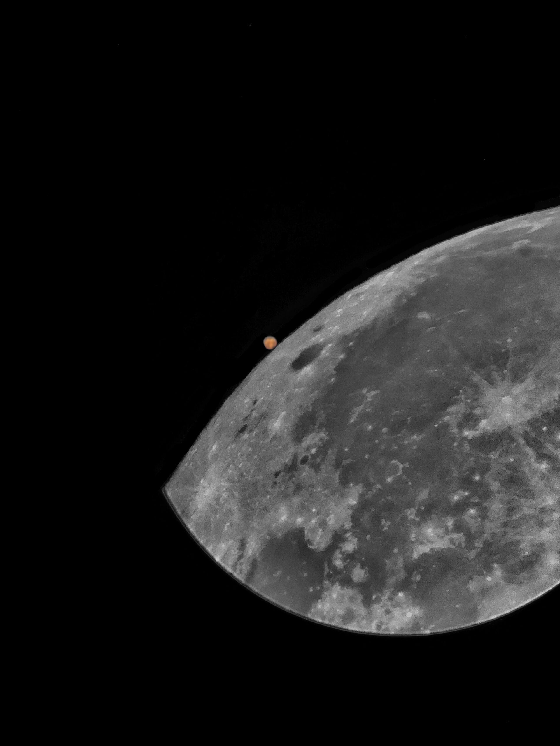 the moon large in the foreground with mars smaller in the background