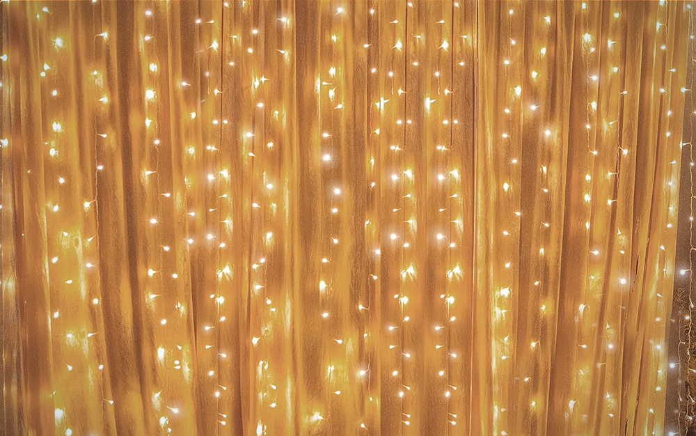 The Twinkle Star Window Curtain Lights on a white wall