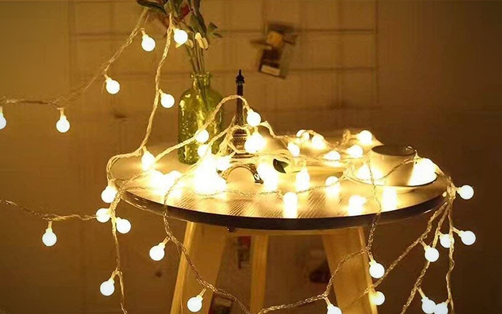 The RaThun globe string lights light up on a stool
