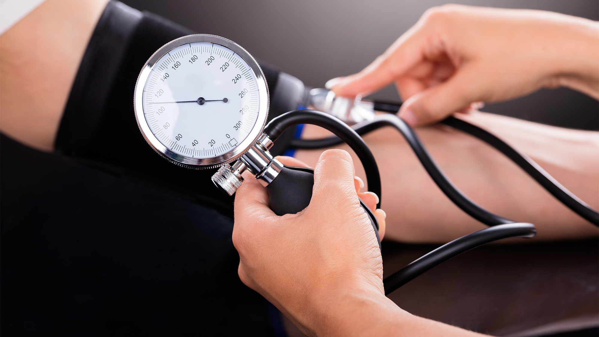 A doctor uses a blood pressure cuff to take a patient's blood pressure.