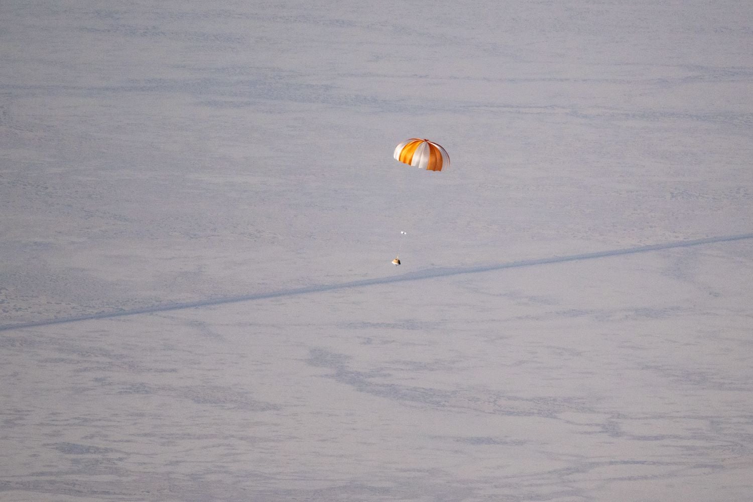 A parachute above a plain desert.