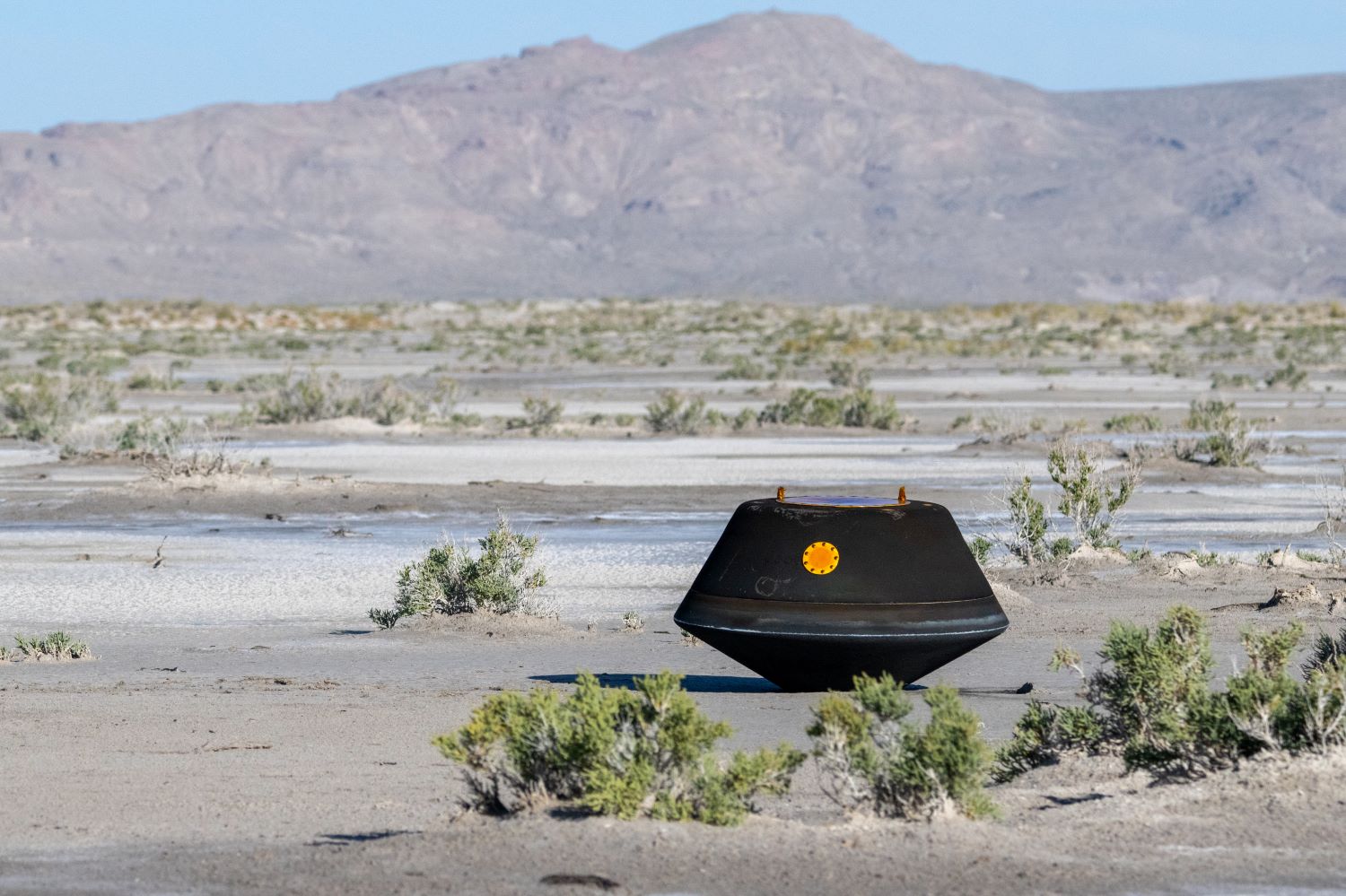 The sample return capsule from NASA’s OSIRIS-REx mission is seen shortly after touching down in the desert.