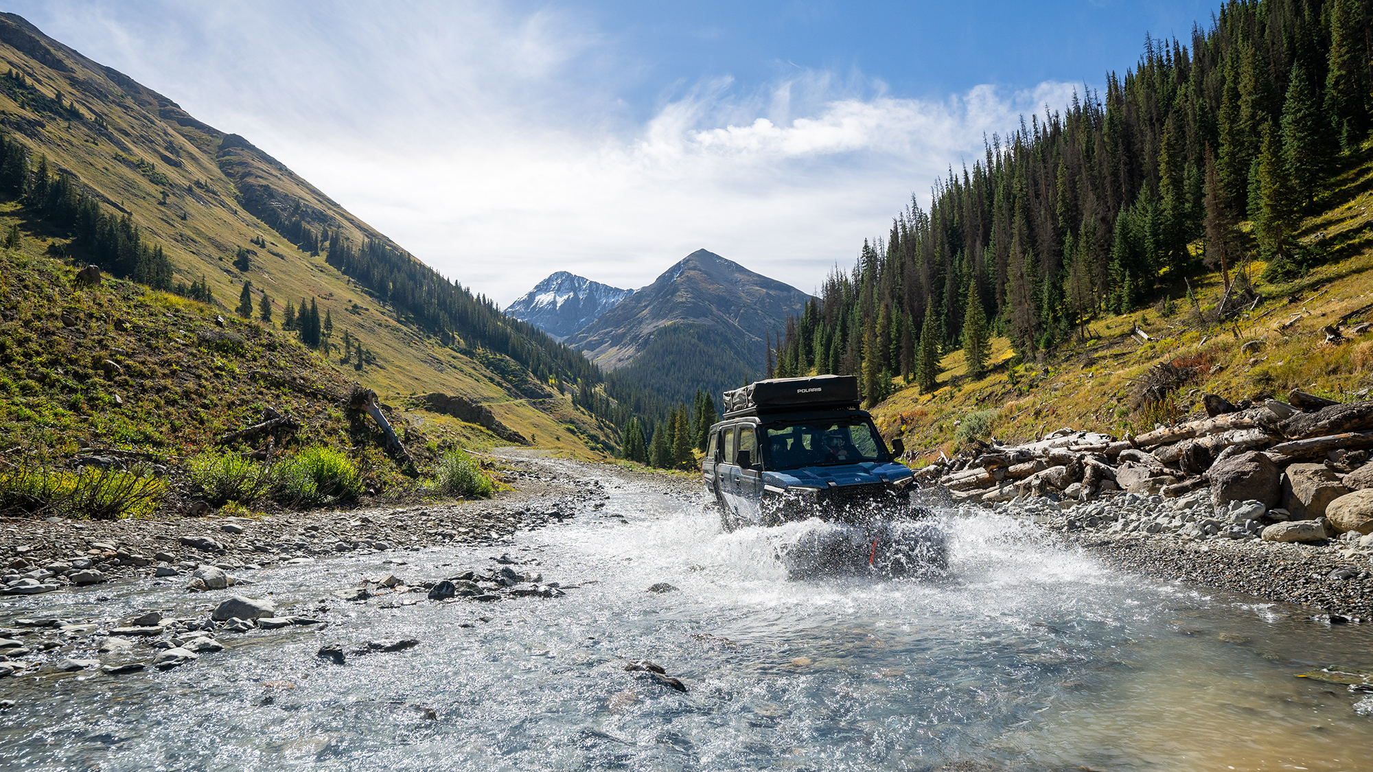 The 2024 Polaris Xpedition vehicle crossing a river