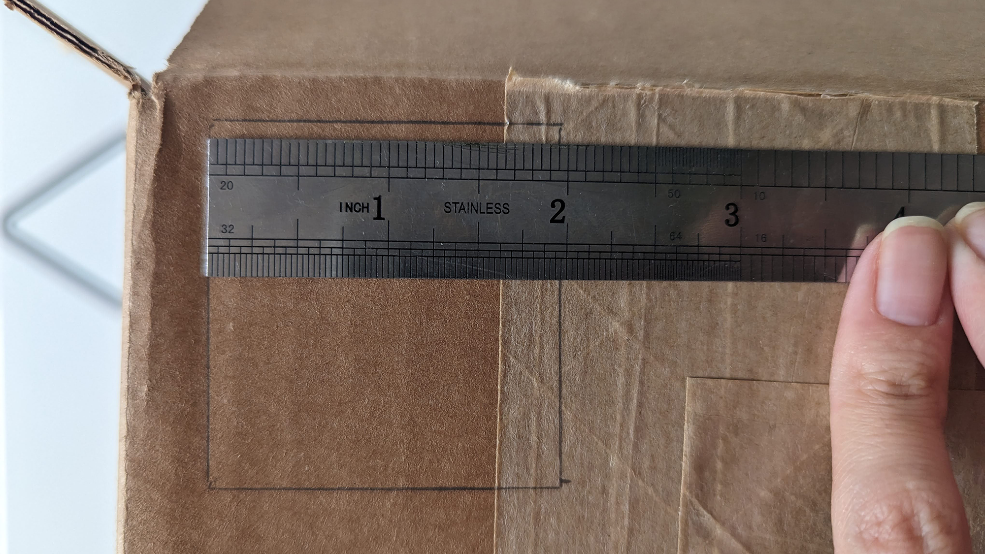 Χάρακας που μετρά ένα τετράγωνο σε ένα χαρτόκουτο. 