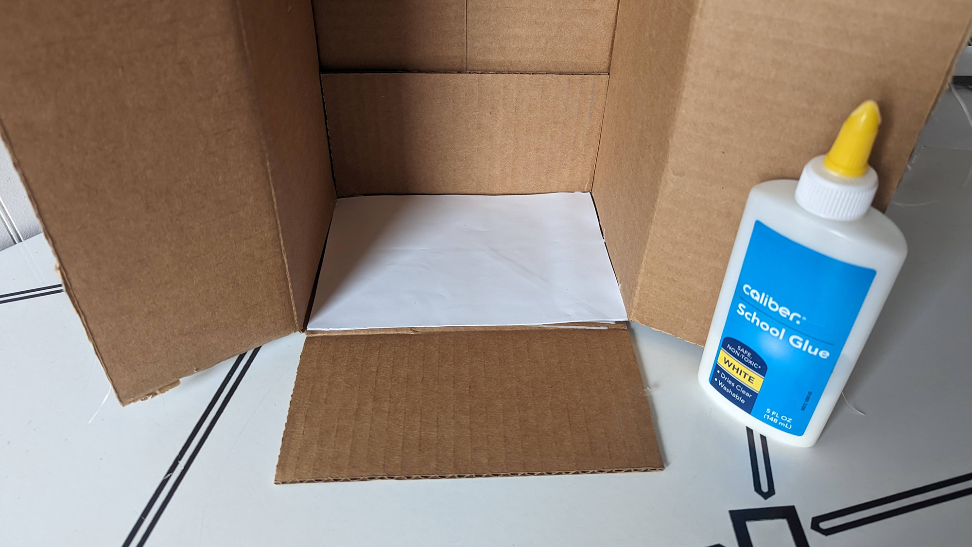 Λευκό φύλλο χαρτιού κολλημένο στο εσωτερικό ενός κουτιού.