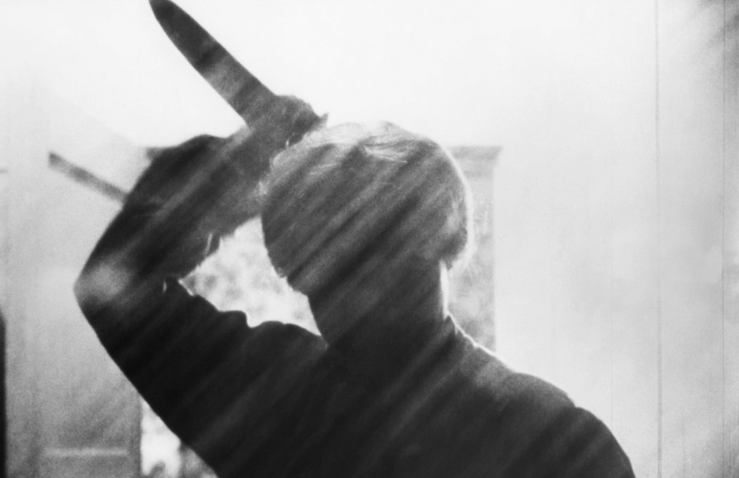 A movie still from 'Psycho,' showing the silhouette of a man holding a knife.