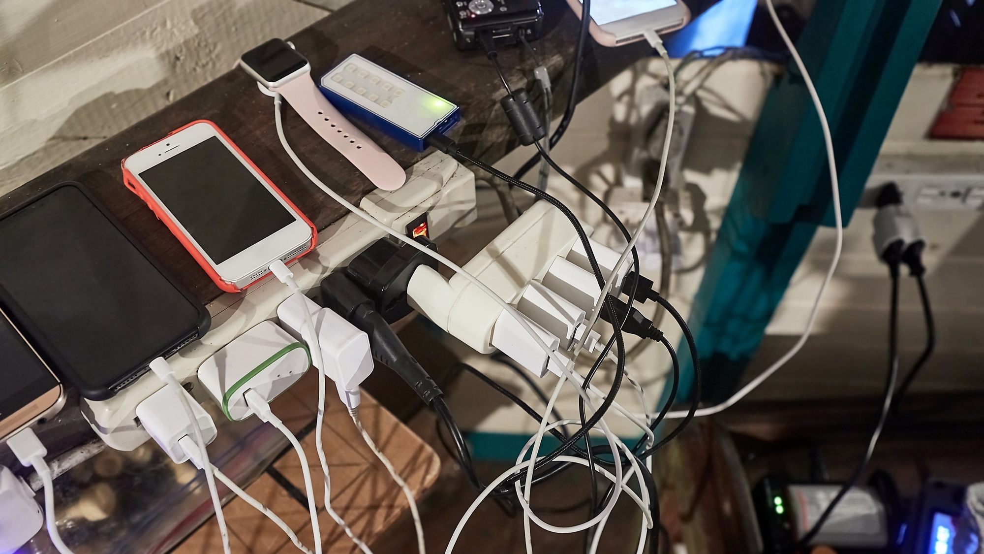 Lots of chargers for devices tangled in a crowded corner