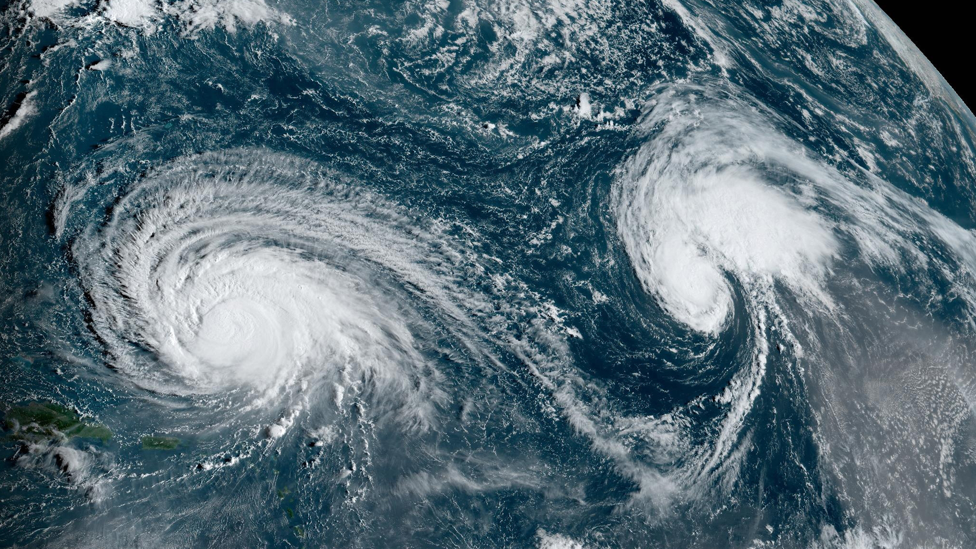 A satellite photo showing the swirling clouds of Hurricane Lee and Tropical Storm Margot in the Atlantic Ocean.