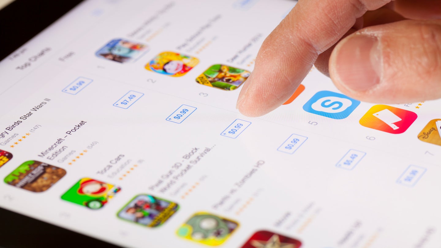 A person's hand selecting options of iPad apps in Apple's App store.
