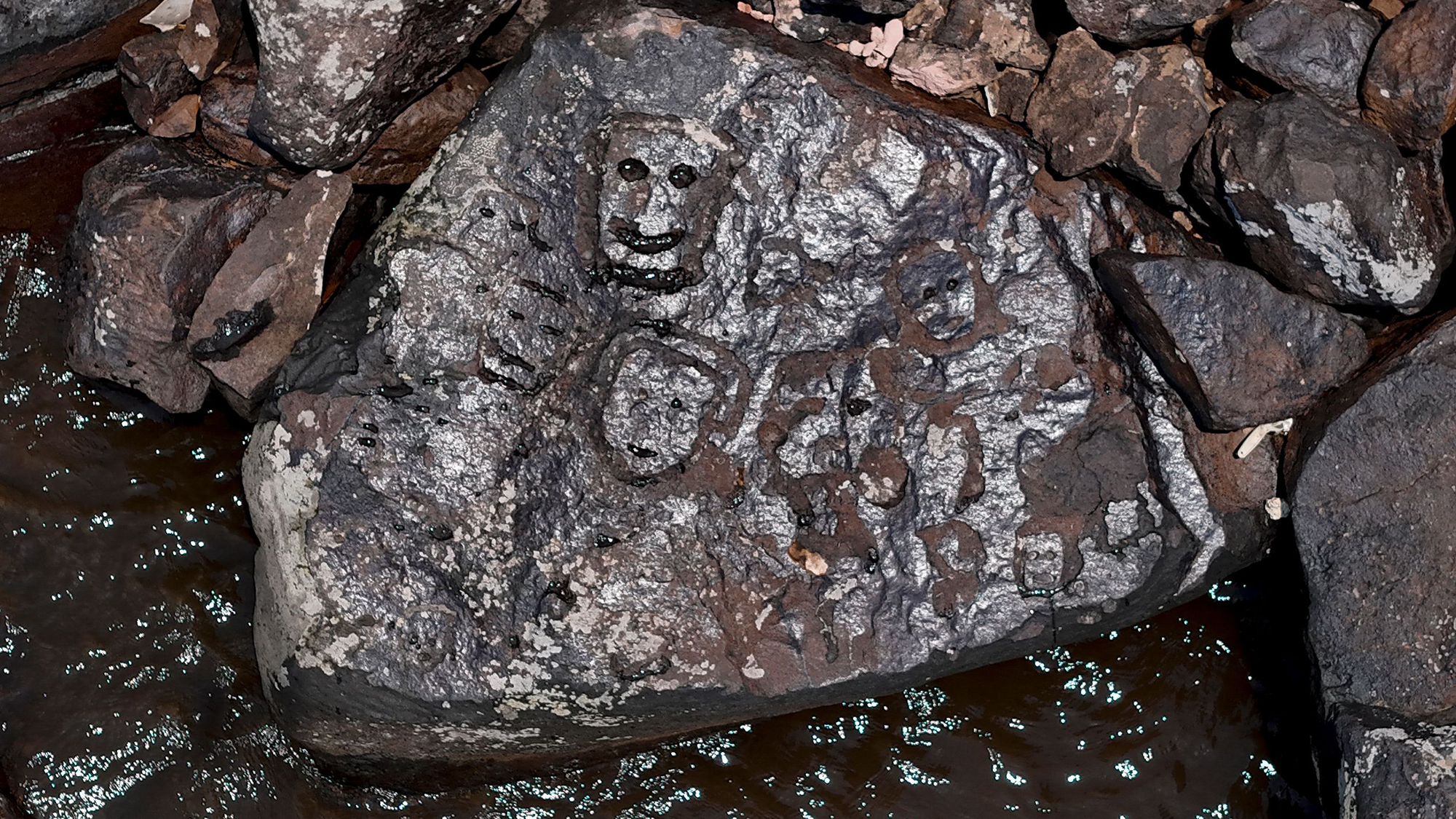 Drought reveals ancient rock carvings of human faces in Brazil