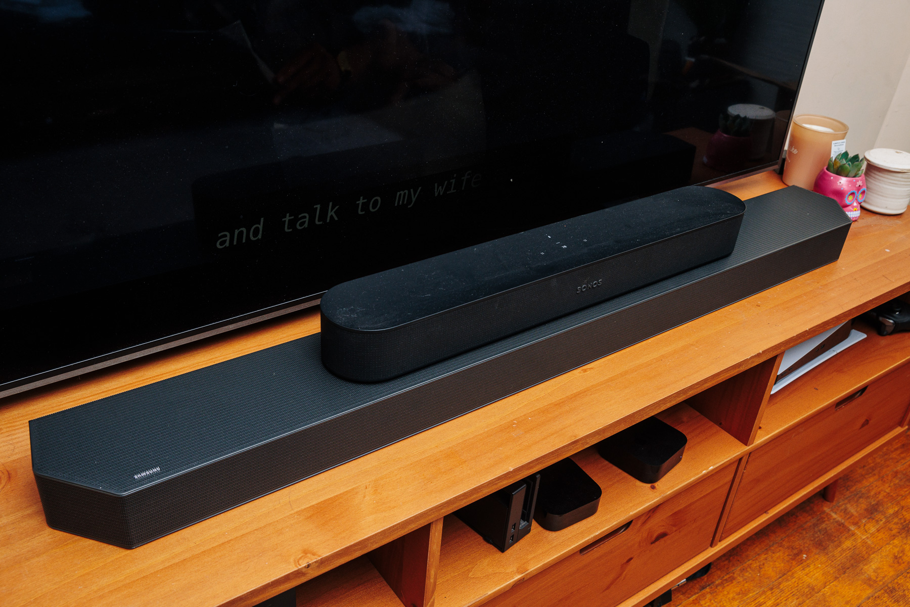 Samsung Q900C soundbar with a Sonos Beam soundbar sitting on top of it in front of a TV