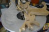 A person cutting a reindeer figurine out of wood on a scroll saw.