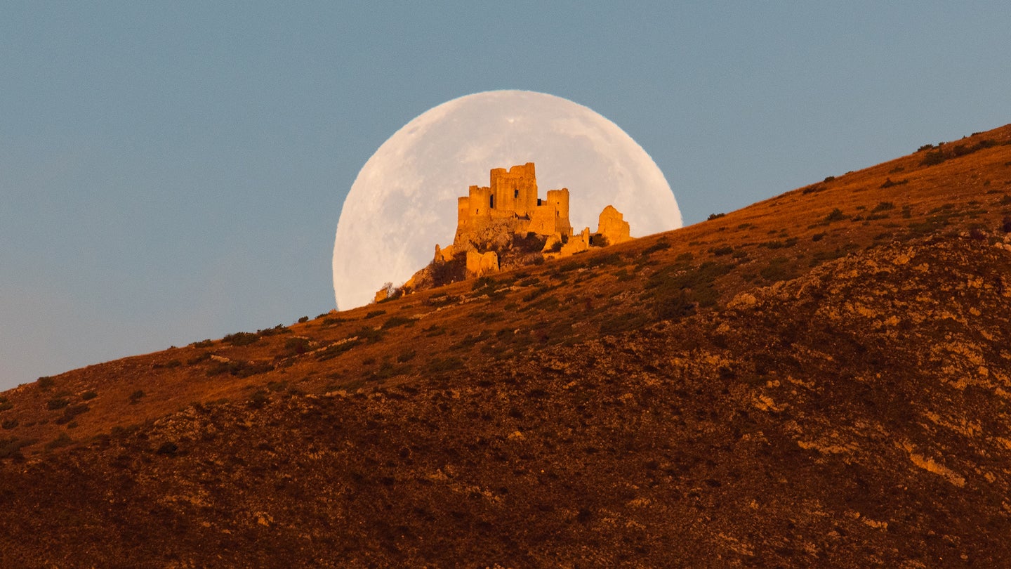 Beaver moon sets behind Rocca Calascio castle in Calascio, Italy, on November 9, 2022. November full moon takes this name because during this month beavers fill the banks of rivers and build their dams and dens to take refuge in view of winter.