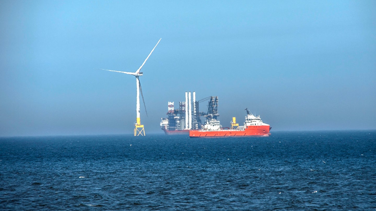 Offshore wind turbine being constructed with nearby supply ship