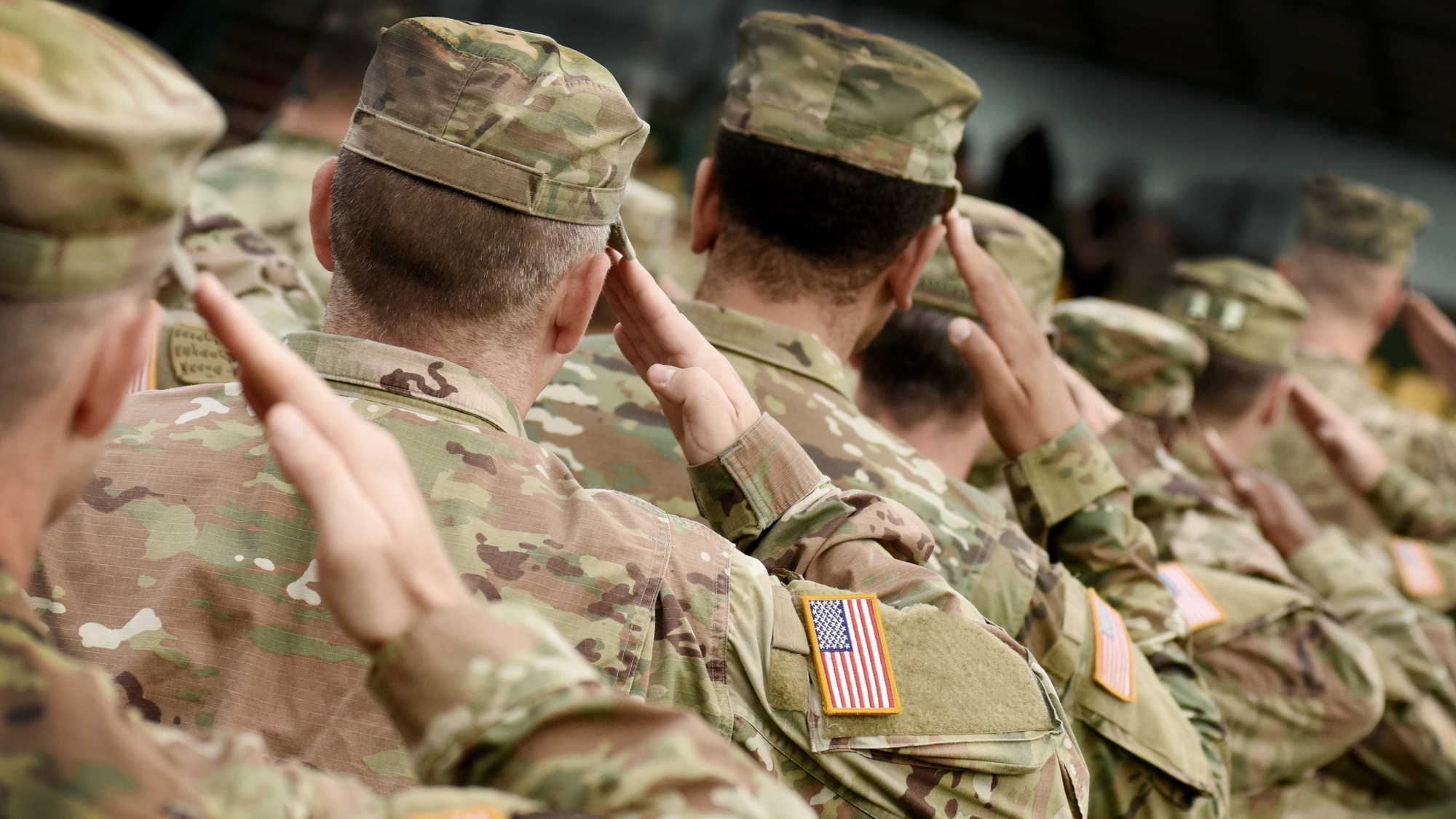 Over shoulder image of US soldiers saluting