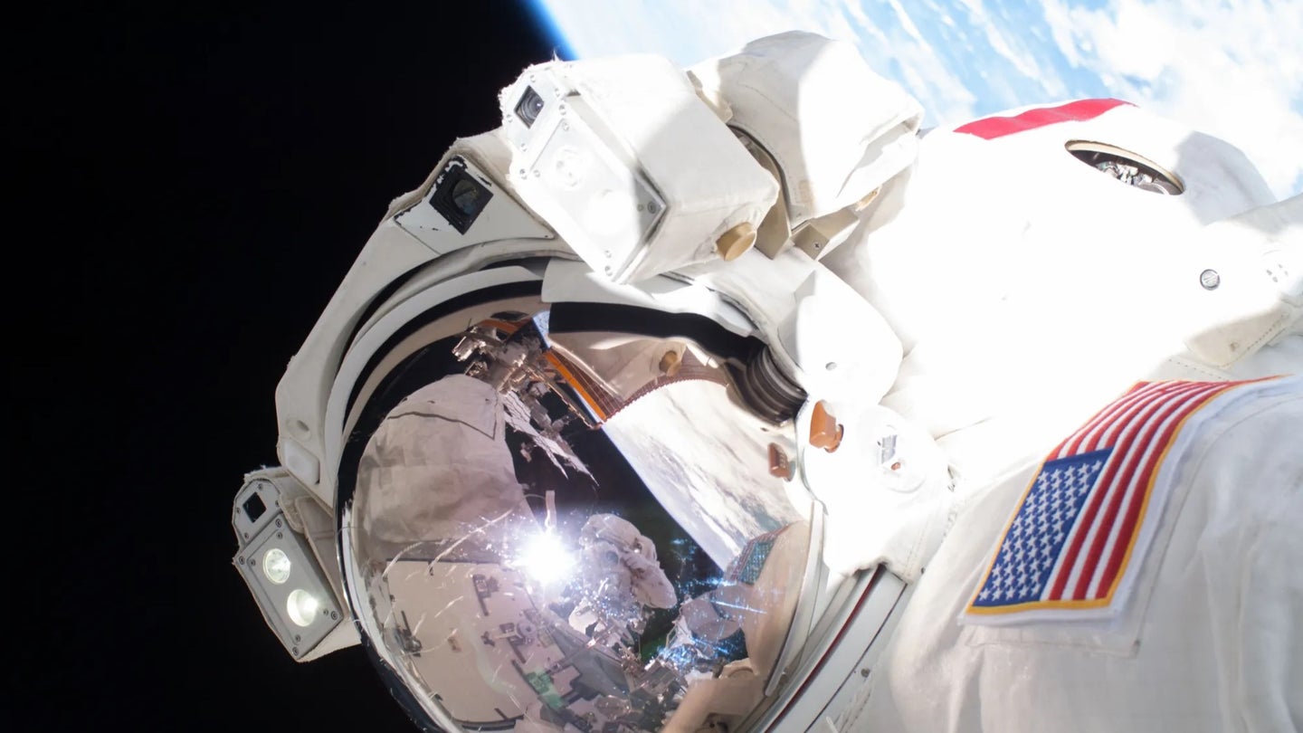 An astronaut in a white spacesuit with Earth in the background.