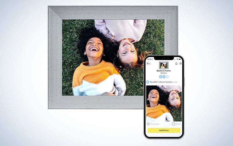 A picture of two little kids laughing in a gray picture frame next to an iPhone with the same image of the kids.
