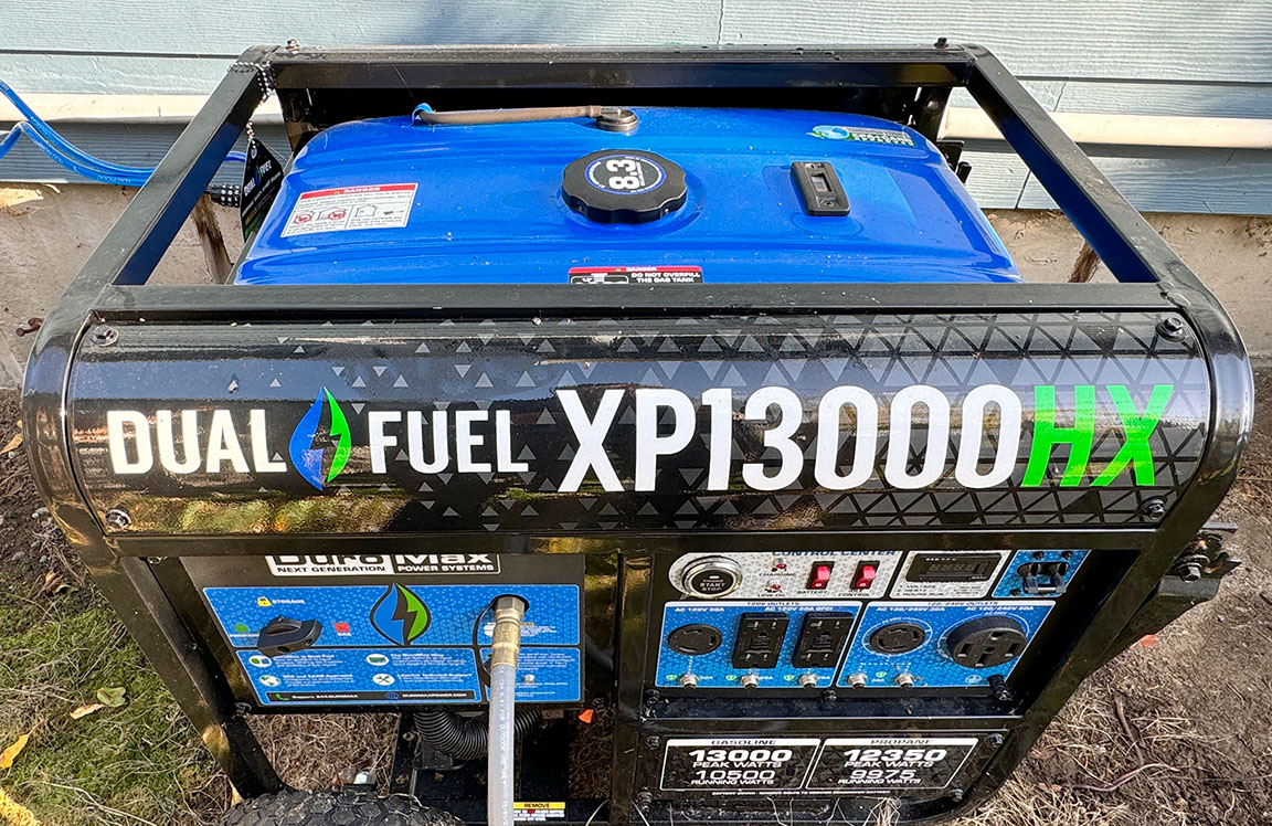 Black and Blue DuroMax HP13000HX dual-fuel generator running outdoors next to a house