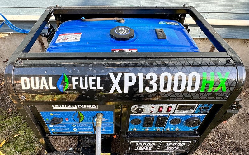 Black and Blue DuroMax HP13000HX dual-fuel generator running outdoors next to a house