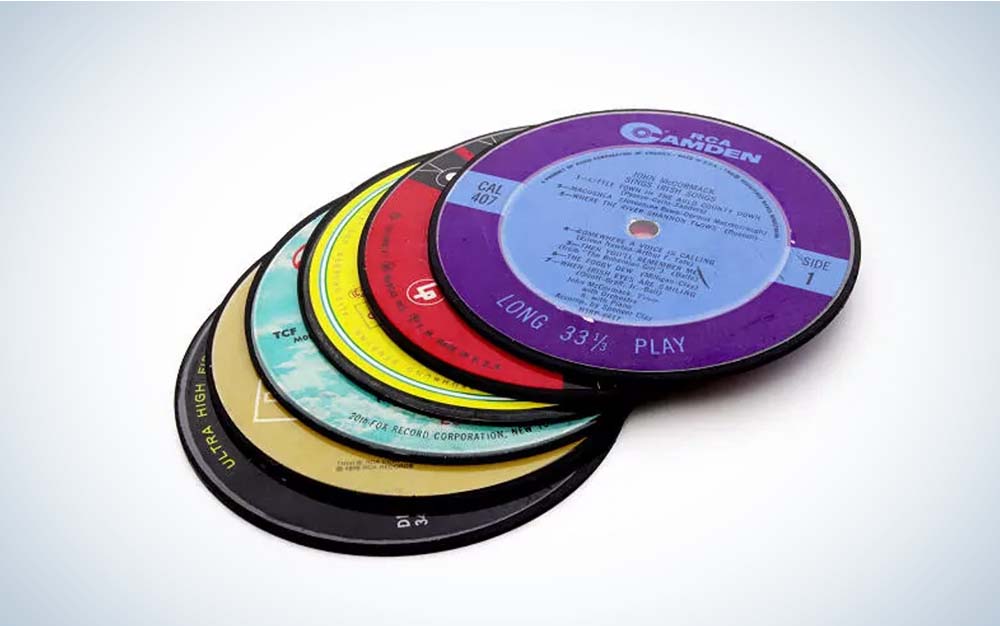 Six coasters in different colors made from vinyl records arrayed in a stack.
