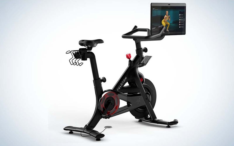 A black Peloton Bike Plus with a seat, handlebars, and a 24-inch touchscreen.