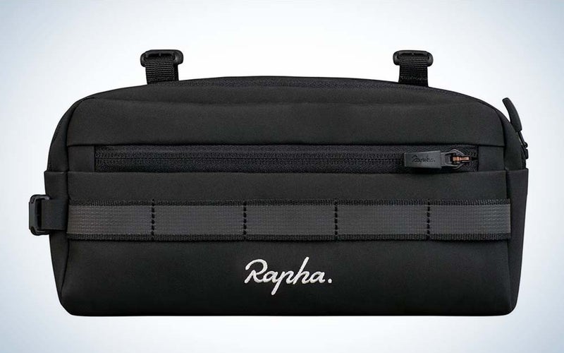 A black polyester bike bag with straps and the word "Rapha" in white letters on the front against a plain background.